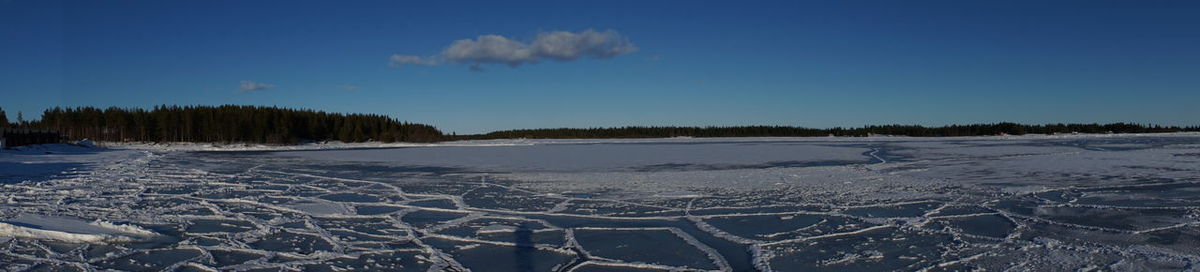 Scenic view of frozen landscape against blue sky