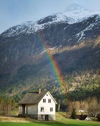 Scenic view of rainbow over mountain against sky