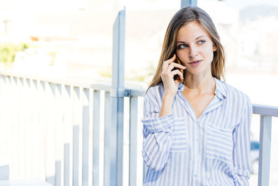 Portrait of man standing on railing