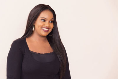 Portrait of smiling young woman against white background