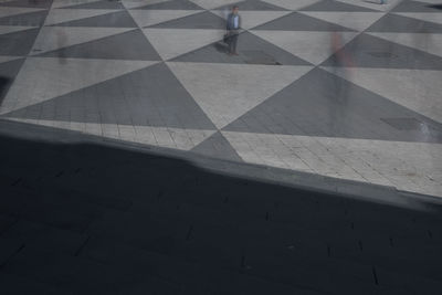 Low section of person walking on tiled floor