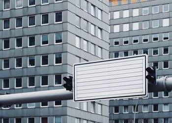 Blank road sign against building