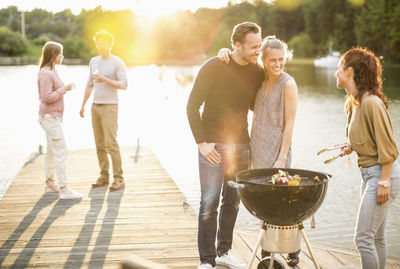 Friends enjoying barbecue party on pier