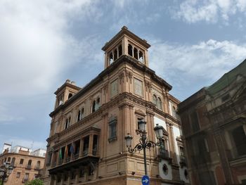 Low angle view of building against cloudy sky