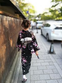 Rear view of woman walking on street