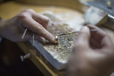 Midsection of person working on a handmade ring