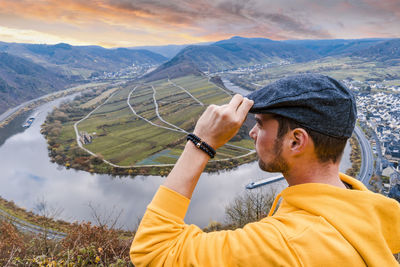 Close-up of man looking at view on mountain against sky