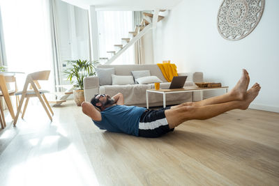 Low section of woman exercising on floor at home