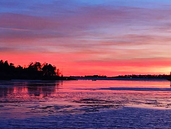 Scenic view of lake against romantic sky at sunset