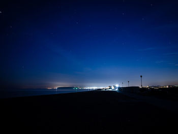 Scenic view of beach against blue sky at night