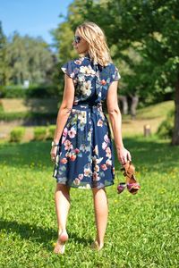 Beautiful blond woman in the park holding her shoes in hand