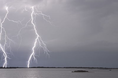 Lightning over sea against storm clouds
