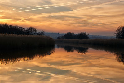 Scenic view of lake against orange sky