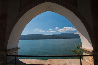 Scenic view of lake seen through arch