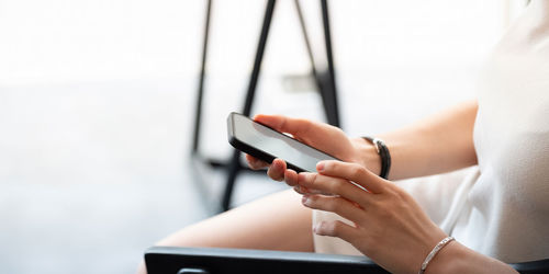 Midsection of woman using mobile phone