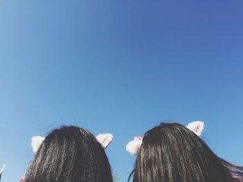 Rear view of women against clear blue sky