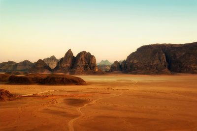 Rock formations on landscape against sky during sunset