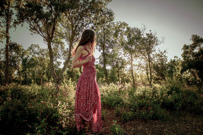 Young woman in the middle of a forest in long summer dress