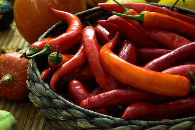 Close-up of red chili peppers in wicker container on table