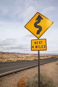 Close-up of road sign against sky