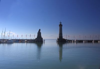 View of building by sea against clear blue sky