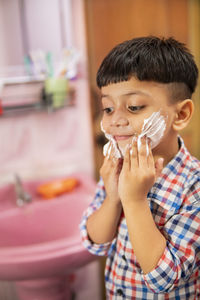 Portrait of boy holding ice cream at home