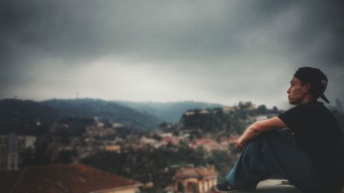 Woman standing on mountain against sky