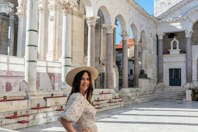 Portrait of happy young woman on peristyle of diocletian's palace in split, croatia
