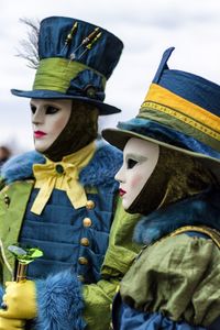 Close-up of people wearing mask and costume against sky