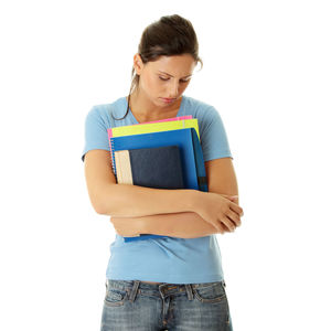 Young woman looking away while standing against white background