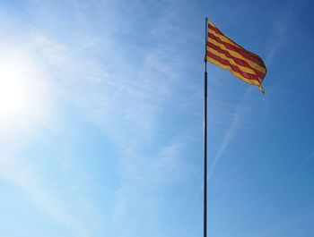 Low angle view of flag against blue sky