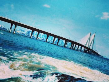 Bridge over sea against blue sky