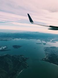 Airplane flying over sea against sky