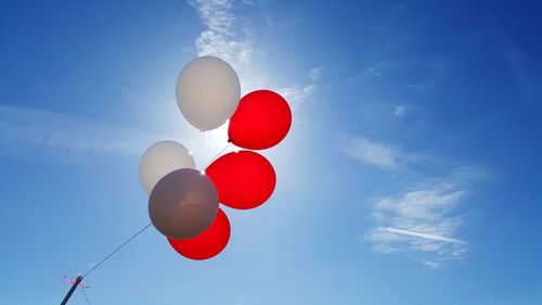 Low angle view of balloons against blue sky