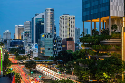 Light trails on road amidst buildings against sky in city
