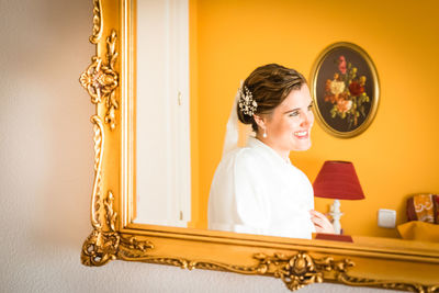 Portrait of young woman against wall at home