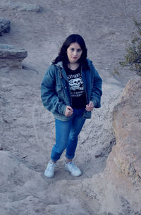 Portrait of young woman standing on sand