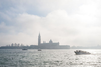 Boat moving on grand canal by san giorgio maggiore against sky