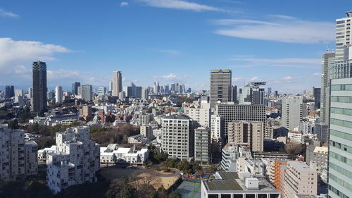 Aerial view of buildings in city against sky