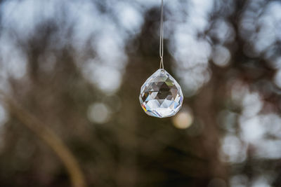 Close-up of crystal ball hanging on glass