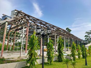 Low angle view of unfinished building or house and palm trees against sky