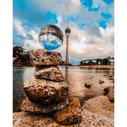 Scenic view of rocks by river against sky