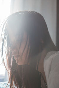 Close-up of young woman lying on bed at home