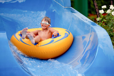 Portrait of cute boy sitting on inflatable ring