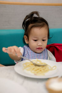 Portrait of cute boy sitting on table
