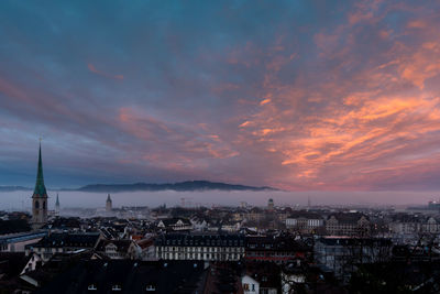 High angle view of townscape against cloudy sky during sunset