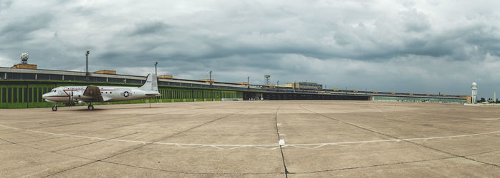 Airplane on airport runway against sky