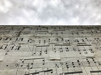 Low angle view of text on brick wall