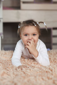 Close-up of cute baby boy lying on bed