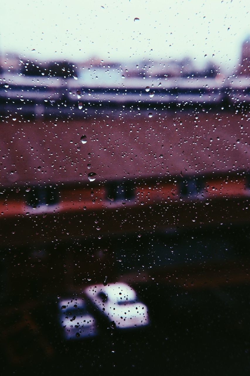 CLOSE-UP OF WATER DROPS ON WINDOW AGAINST SKY